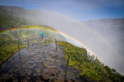 Scenic view of rainbow over land against sky