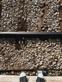 Low section of person standing on railroad track