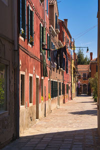 Footpath amidst buildings against sky