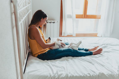 Side view of woman relaxing on bed at home