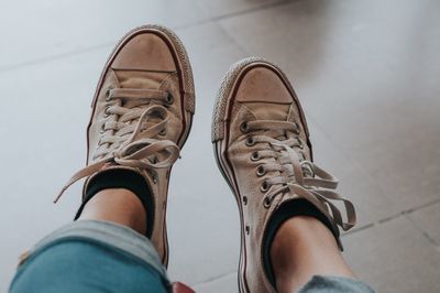 Low section of woman wearing shoes over floor