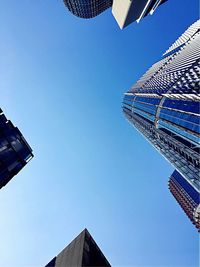 Low angle view of modern buildings against clear blue sky