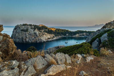 Scenic view of rocks on beach against sky