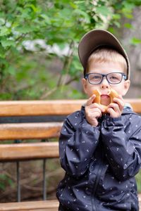 Funny boy with glasses and a bagel. hilarious photo of a child wearing glasses. 