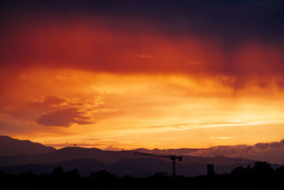 Scenic view of silhouette mountains against orange sky