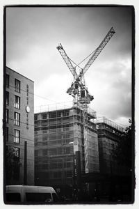 Low angle view of crane against sky