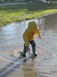 Full length of boy playing in a puddle