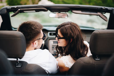 Portrait of young woman sitting in car