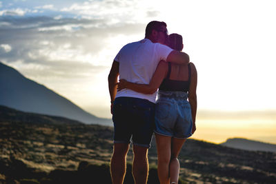 Rear view of friends standing against the sky