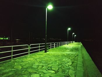 Illuminated street lights on footpath at night