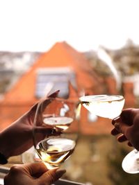 Cropped hands toasting wineglasses