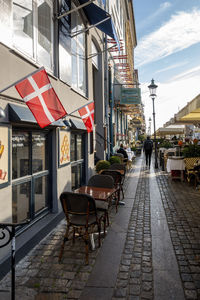 Sidewalk cafe by street in city