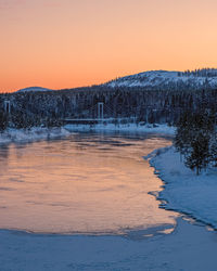 Scenic view of frozen lake against orange sky