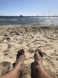 Low section of people relaxing on beach