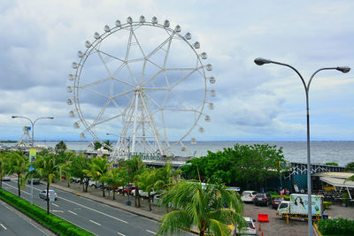 View of ferris wheel against cloudy sky