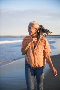 Gray haired woman enjoying the beach at sunset