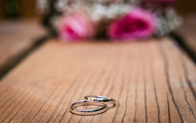 Close-up of wedding rings on wooden table