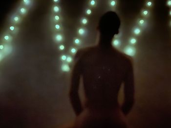 Rear view of woman in illuminated music concert