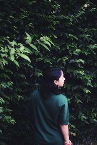 Rear view of woman standing against plants