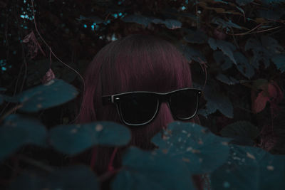 Woman wearing sunglasses amidst plants