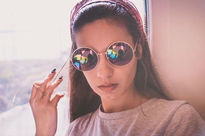 Close-up portrait of young woman wearing sunglasses