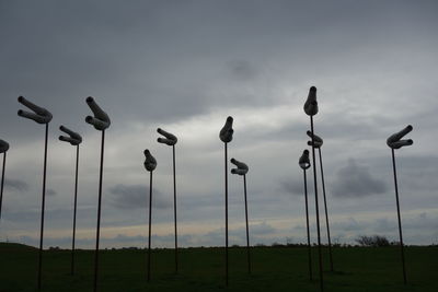 Low angle view of street lights on field against sky