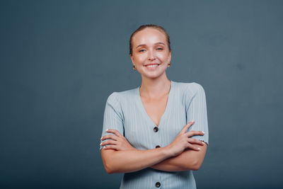 Portrait of a smiling young woman against gray background