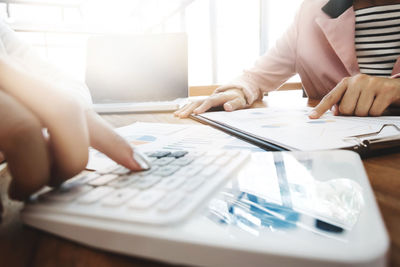 Midsection of man using laptop on table