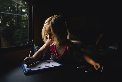 Portrait of a girl sitting on book at home