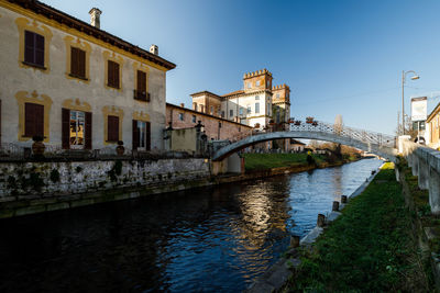 Bridge over river against buildings in city