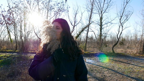 Woman standing by tree on field