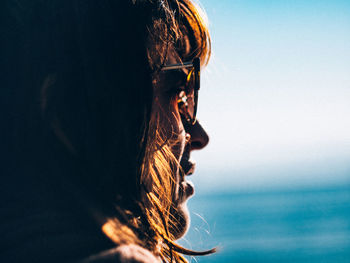 Close-up of young woman against sky