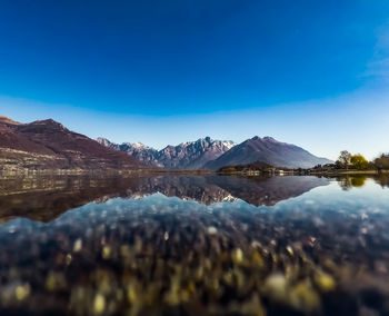 Scenic view of lake and mountains against blue sky