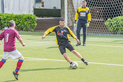 People playing soccer ball on field