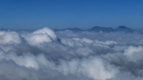 Scenic view of mountain range against cloudy sky