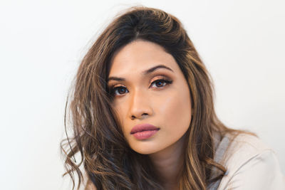 Close-up portrait of a beautiful young woman over white background