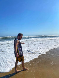 Full length of man on beach against clear sky