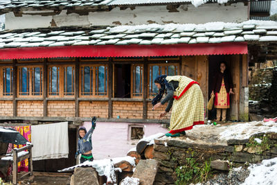 People outside house in village