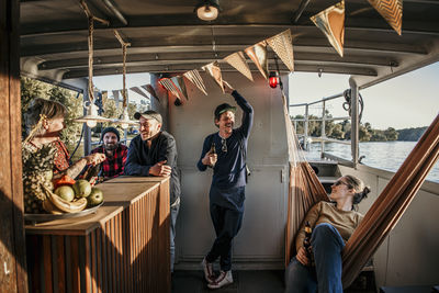 Happy friends spending leisure time together on boat on sunny day