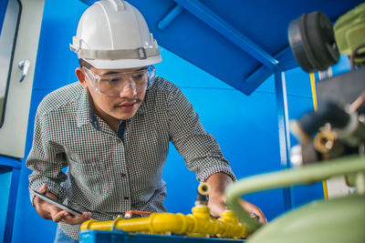 Man examining machinery at factory