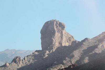 Rock formations on mountain against clear sky