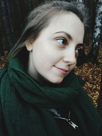 Close-up of smiling young woman looking away during autumn