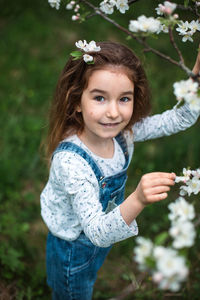 Portrait of young woman standing by plants