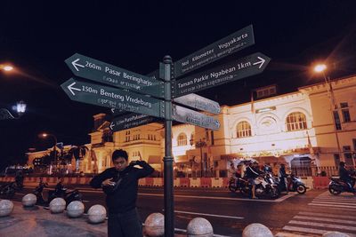 People on illuminated street at night