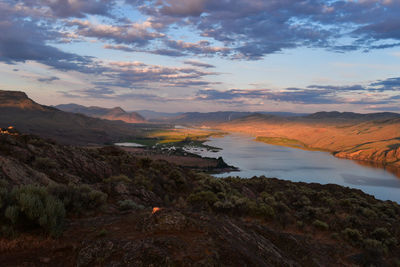 Scenic view of lake and landscape against sky during sunset