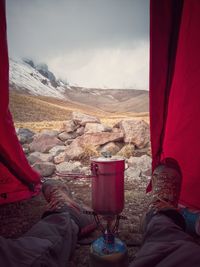 Low section of man in tent with mountains in background