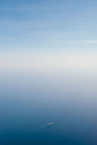 Aerial view of boat on ocean in foggy weather