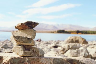 Stack of rocks against sky on sunny day