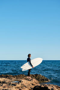 Man standing in sea against clear sky