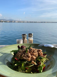 Food on table by sea against sky